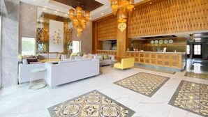 A spacious lobby with a reception desk, seating area, and decorative lighting. - Holiday Pier Hotel (Mandalay)