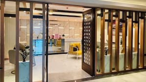 A modern hotel lobby with a glass partition, marble flooring, and contemporary furniture. - Holiday Pier Hotel (Mandalay)