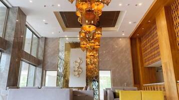 A lobby with a modern chandelier, seating areas, and a decorative wall.