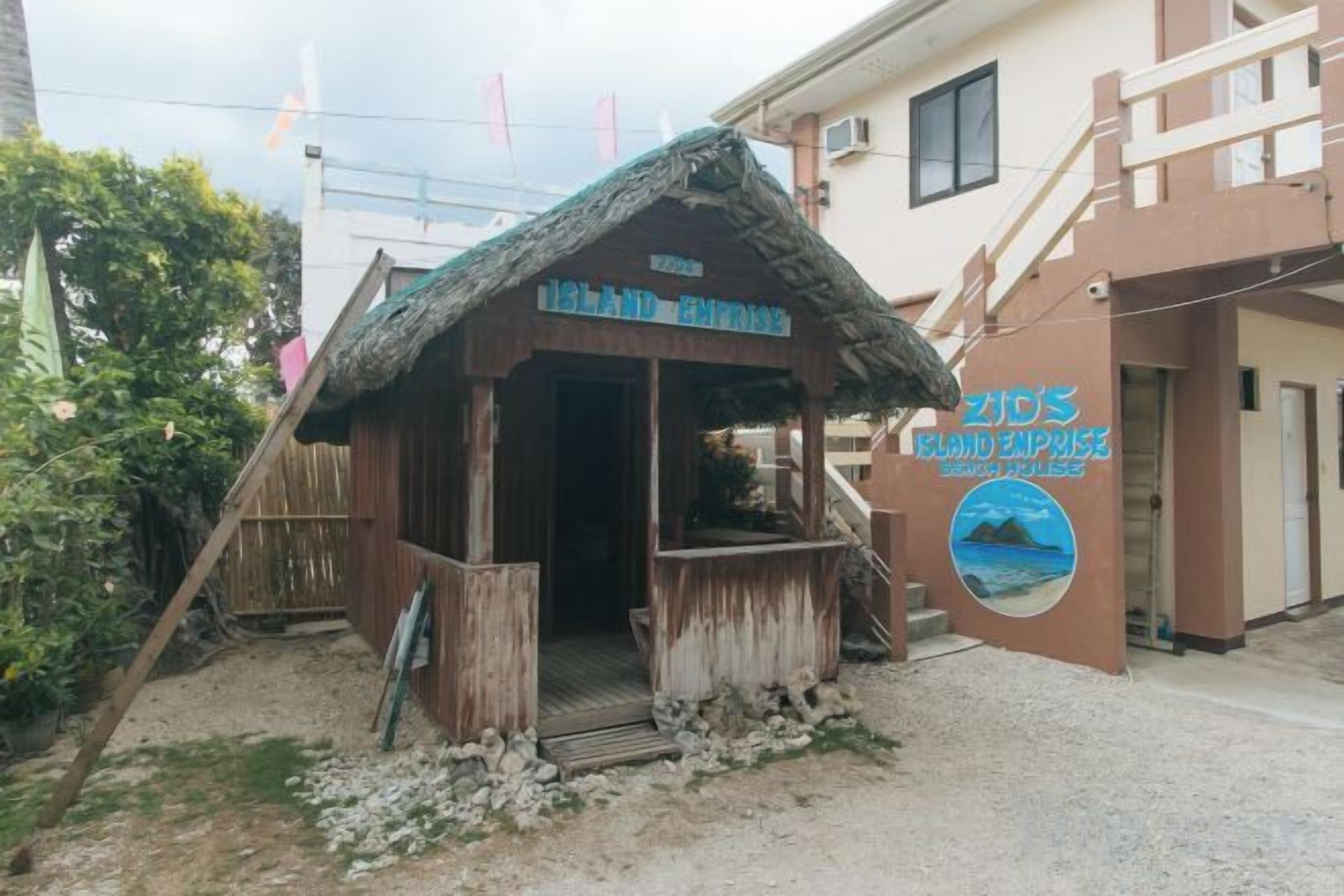 A wooden structure with a thatched roof labeled 'Island Inn' and 'ZICO'S BIRD EXPRESS' on the wall.