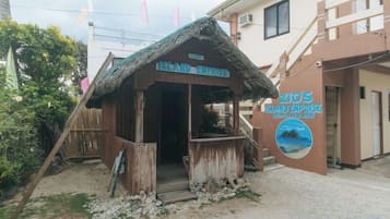 A wooden structure with a thatched roof labeled 'Island Inn' and 'ZICO'S BIRD EXPRESS' on the wall.