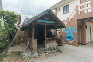 A wooden structure with a thatched roof labeled 'Island Inn' and 'ZICO'S BIRD EXPRESS' on the wall.