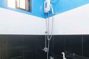 A bathroom with a shower, a mirror, and a window.
