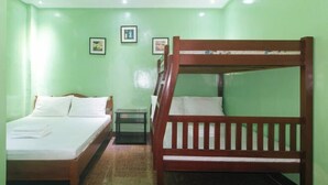 A room with two beds, one with a wooden frame and the other with a metal frame, a small table, and two framed pictures on the wall. - Zids Island Emprise Beach House (Pagudpud)