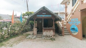 A wooden structure labeled "Island Paradise" with a staircase leading to a building with a sign for "ZID'S GRAND EMPORIS". - Zids Island Emprise Beach House (Pagudpud)