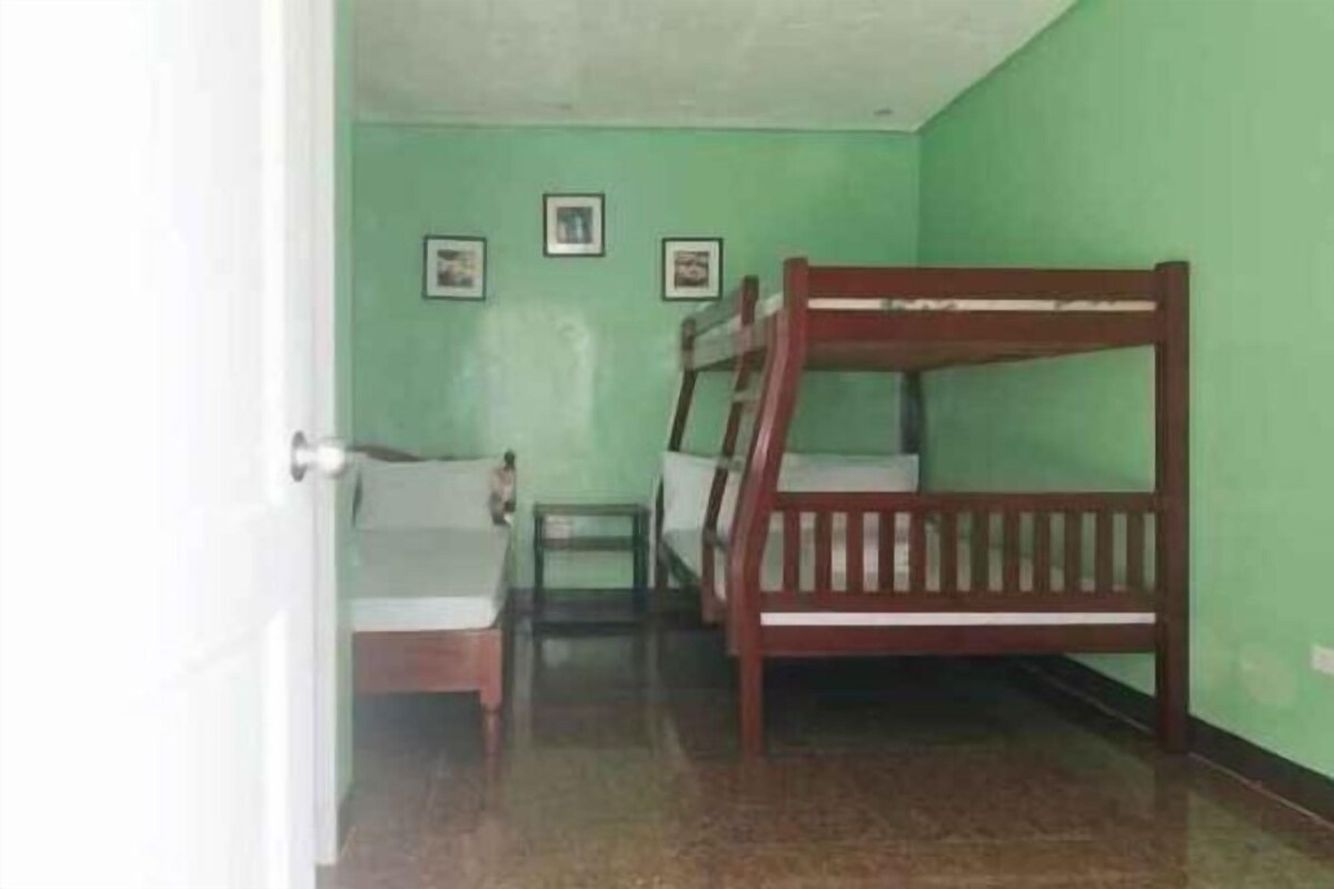 Una habitación con dos literas, una mesita y una silla.