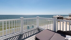 A wooden deck with white railings overlooking a beach and ocean. - New Construction! Beachfront, 3 Bedroom/3.5 Bath, Pool, Hot Tub, Pet Friendly (Dauphin Island)