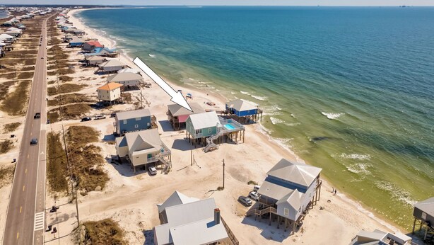 An aerial view of a coastal area with beach houses, a road, and the ocean. - New Construction! Beachfront, 3 Bedroom/3.5 Bath, Pool, Hot Tub, Pet Friendly (Dauphin Island)