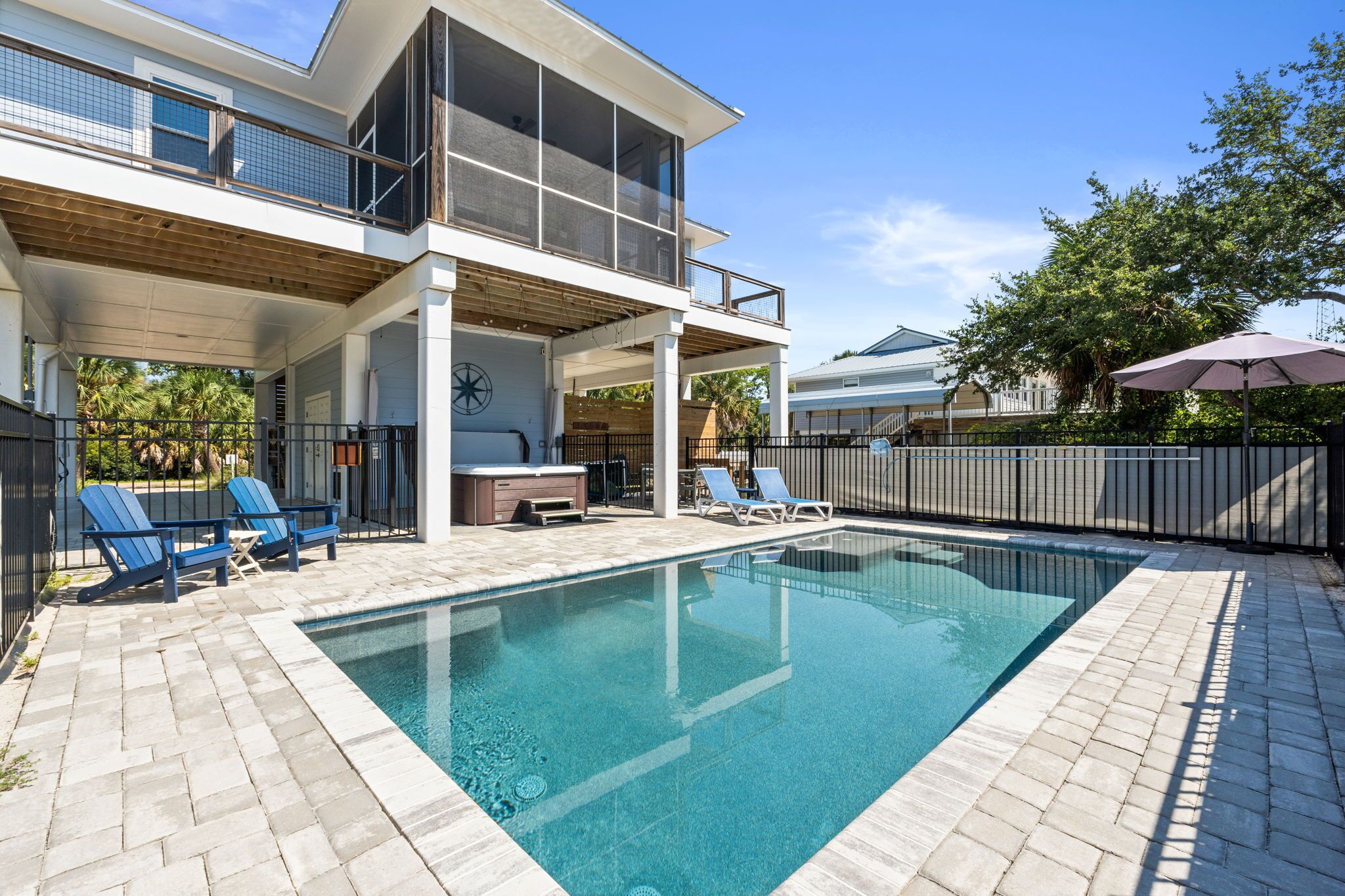 A modern house with a swimming pool, outdoor seating, and a covered patio area.