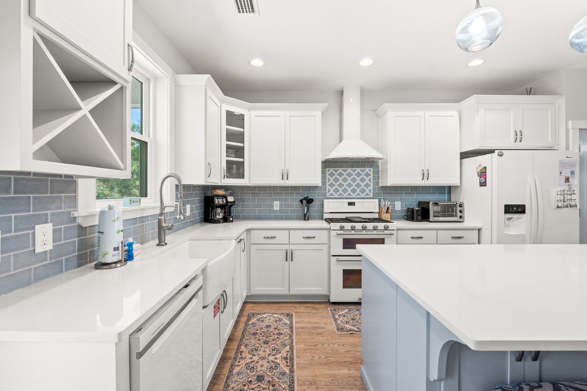 A modern kitchen with white cabinets, a built-in oven, a microwave, and a refrigerator.
