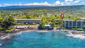 A coastal hotel with multiple buildings, a beachfront, and a view of the surrounding landscape. - Kona Bali Kai#164:Stunning Remodeled Studio with Ocean Views: Walk to Beach! (Kailua Kona)