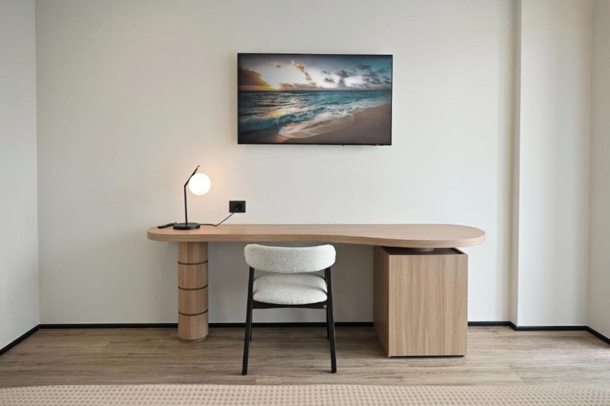 Un bureau moderne avec une chaise, un tableau accroché au mur et une lampe sur pied.