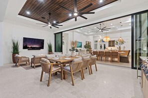 Un comedor amplio con mobiliario de madera y un diseño de techo moderno.