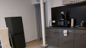 Eine moderne Küche mit Kühlschrank, Mikrowelle und Kaffeemaschine.