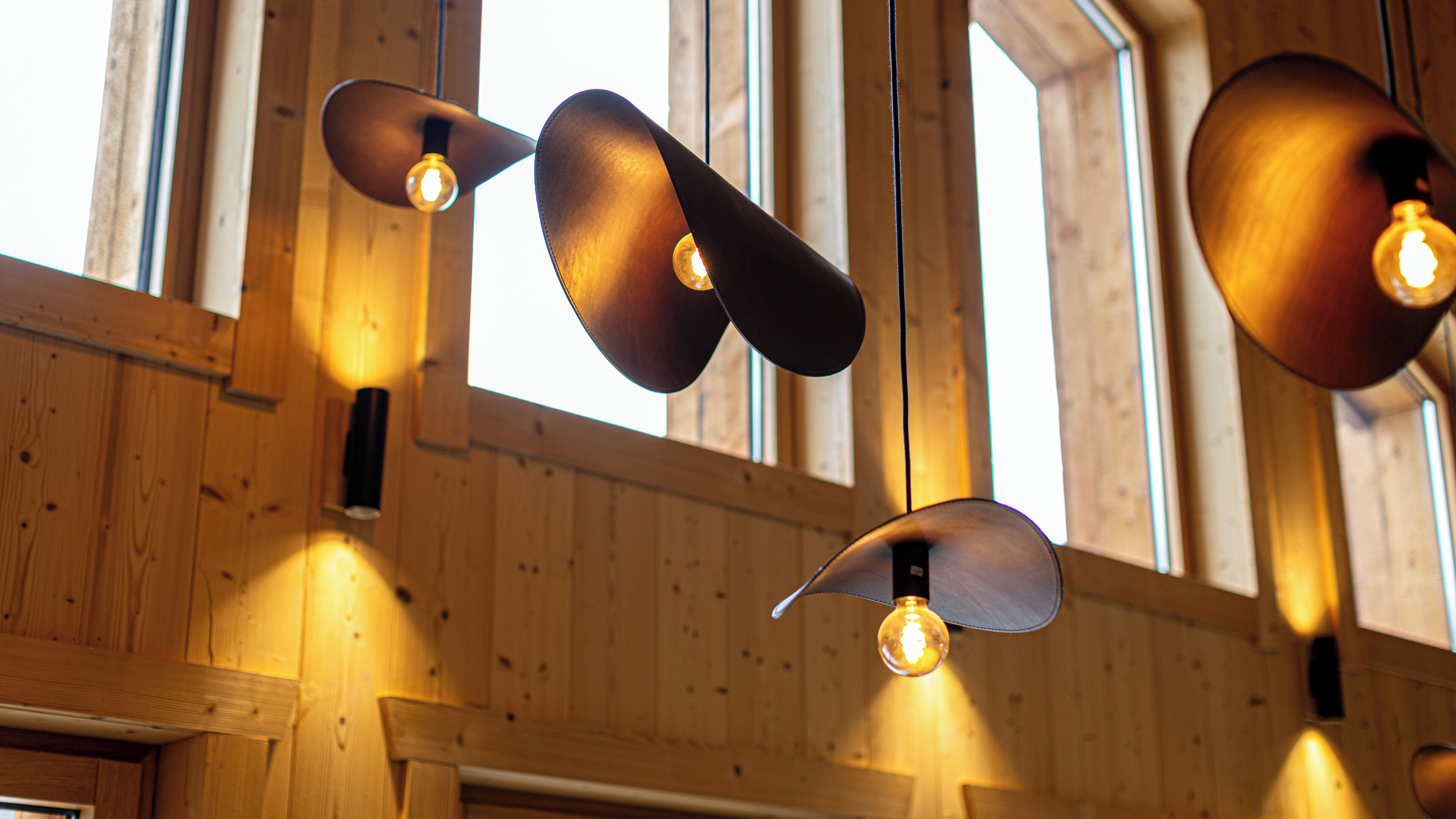 A ceiling with pendant lights and wooden beams.