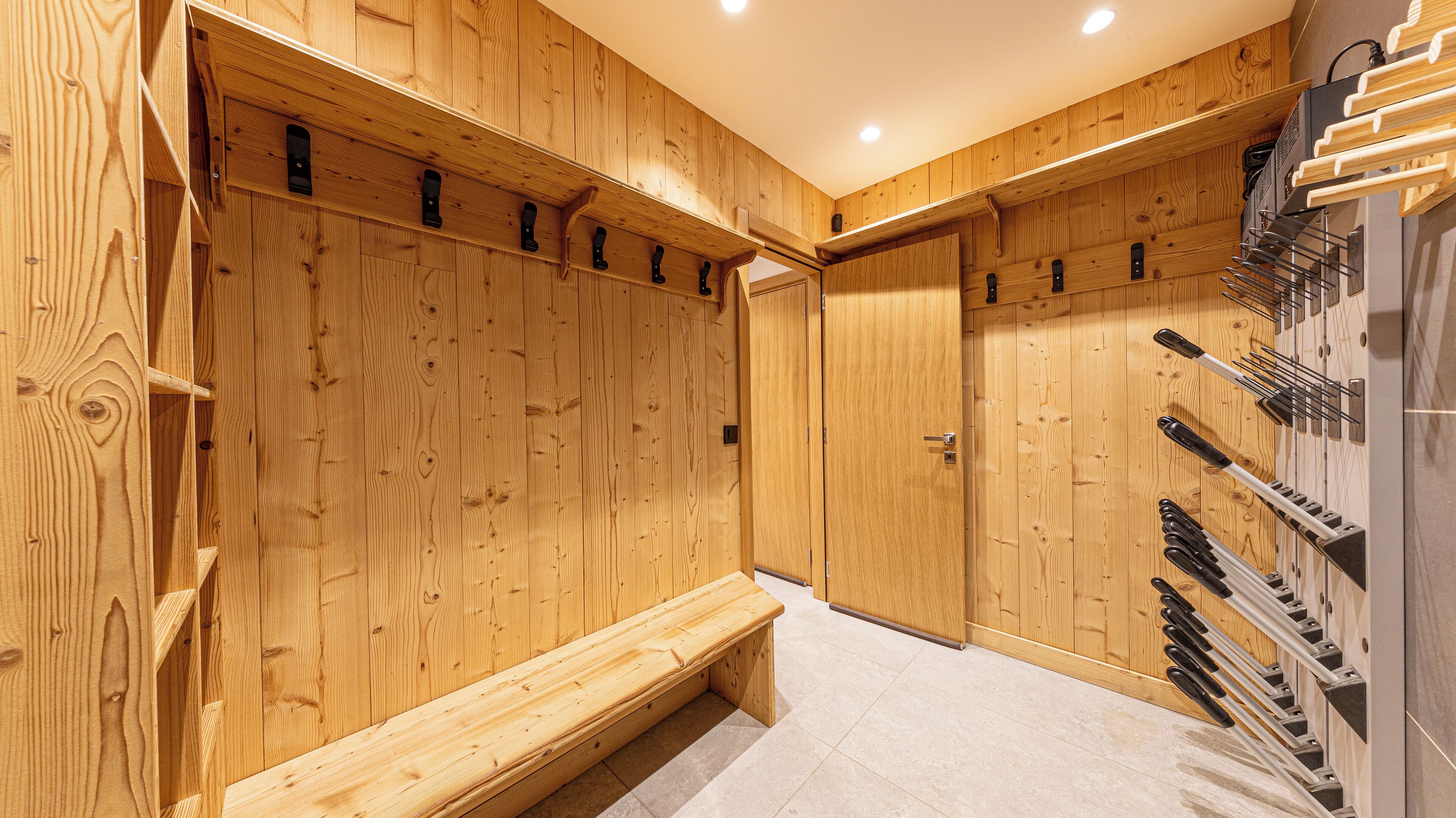 A wooden locker room with benches and a rack of knives.