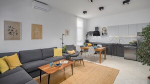 A modern living room with a grey sofa, a wooden coffee table, and a dining area with a table and chairs. - House Runa in Porec, Croatia (Porec)