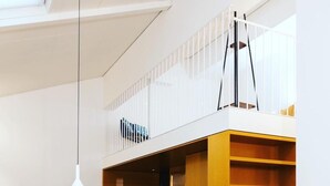 A modern interior with a staircase, a dining area, and a small seating space. - Pepper Suite (Bolzano)