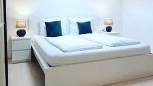 A modern bedroom with a large bed, two bedside tables, and a skylight. - Pepper Suite (Bolzano)