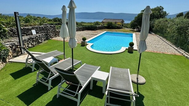 A backyard with a swimming pool, white lounge chairs, and umbrellas. - Pet-Friendly Holiday Home Lara with Pool and Sea view - excellent choice for a relaxing family getaway (Brzac)