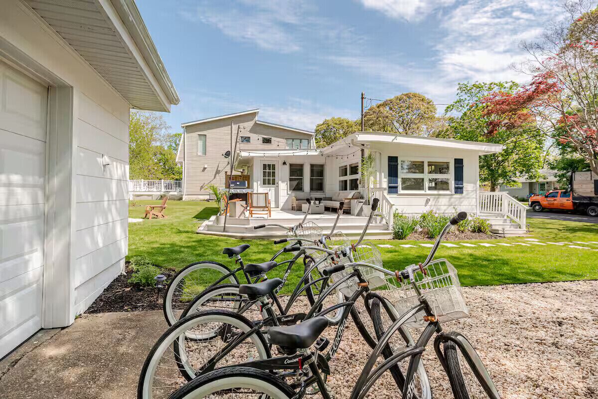A two-story building with a covered patio area, a bike rack with several bicycles, and a small outdoor seating area.