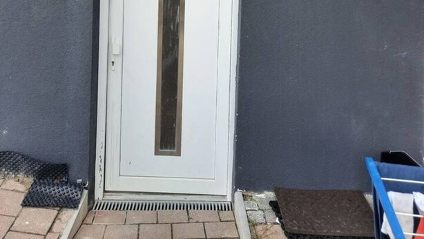 A white door with a vertical window, set in a grey wall. - Flat Bangoua (Abstatt)