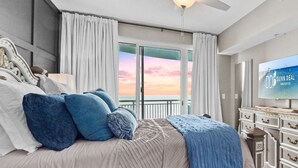 Ein Schlafzimmer mit einem Bett, einem Fernseher, einer Kommode und Blick auf den Himmel.