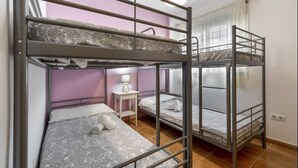 Habitación con literas, mesita de noche y lámpara.