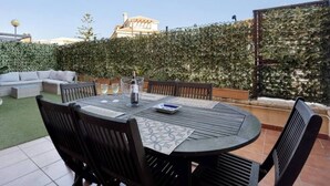 An outdoor patio with a round table, chairs, and a sofa.