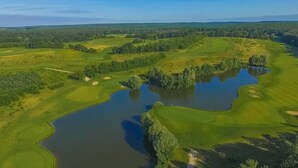 Vista aérea de un campo de golf con varios estanques y zonas verdes.
