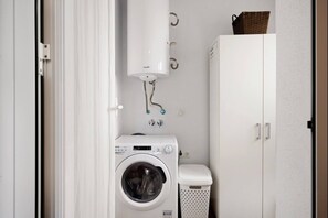 A laundry room with a washing machine, a dryer, and a water heater.
