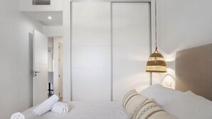 A hotel room with a bed, a wardrobe, and a hanging light fixture. - Isla Candor free parking by Staycare (Rota)