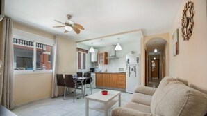 A modern apartment with a dining area, kitchen, and living room.
