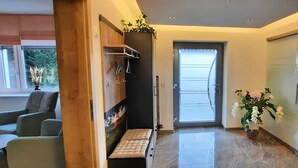 Un intérieur moderne comprenant un coin salon, une porte donnant sur un balcon et une table à manger.