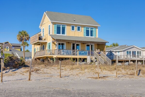 A two-story house with a balcony and a staircase leading to the upper floor. - Spacious 7-bedroom oceanfront home on Folly Beach with breathtaking views, large (Folly Beach)