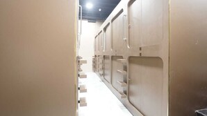A corridor with bunk beds and a white floor. - ASTROPOD (Mumbai)
