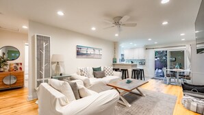 A modern living room with a sofa set, a coffee table, and a dining area with chairs and a table. - Perfect 4 Families, Walk 2 Beach, Private Hot Tub* (Ventura)