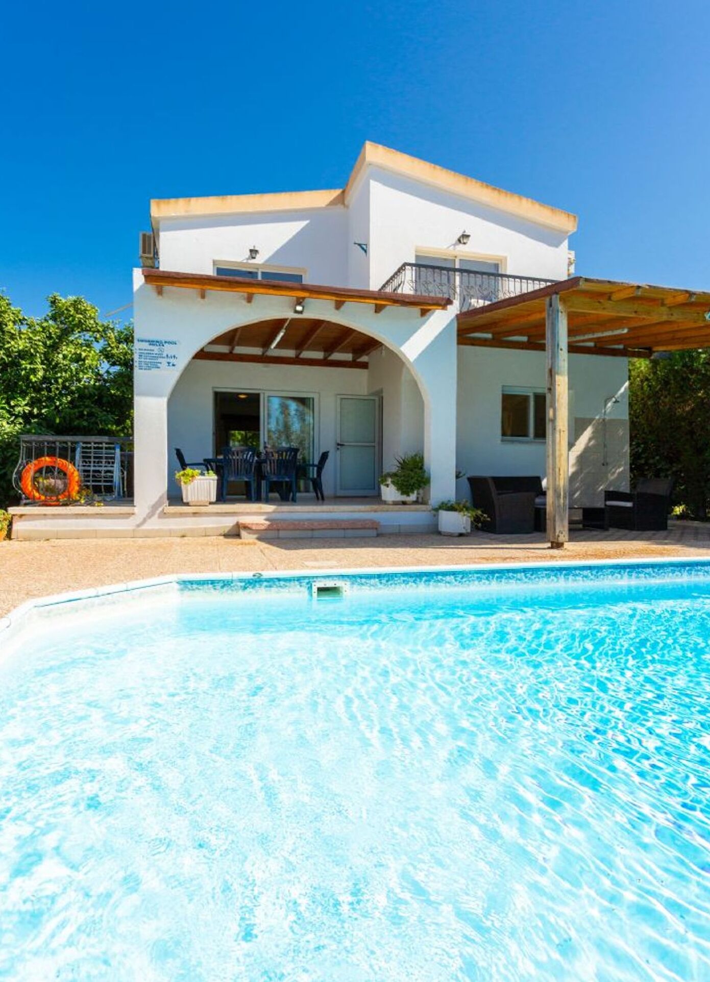 Un bâtiment à deux étages doté d’un patio couvert et d’une piscine.