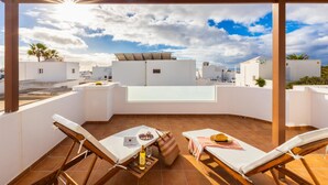 A rooftop terrace with white walls, a glass table, and two lounge chairs. - Villa Dulce in Tias With 4 Bedrooms and 2 Bathrooms (Tías)