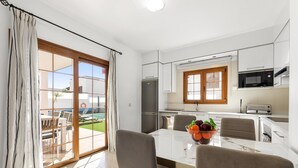 A modern kitchen with white cabinets, a built-in microwave, and a refrigerator. - Las Caletas in Teguise (Teguise)