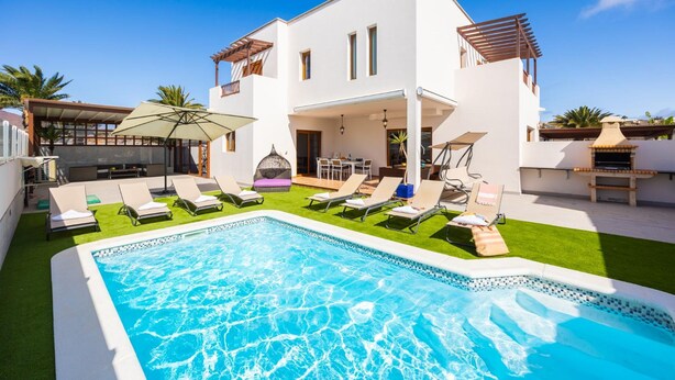 A modern two-story house with a swimming pool, outdoor seating, and a pergola. - Las Caletas in Teguise (Teguise)