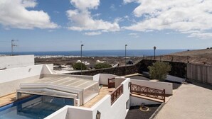 A rooftop pool area with a view of the sea and distant buildings. - Casa Morro Blanco in Conil (Tías)