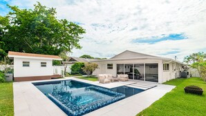 A modern house with a swimming pool, a covered patio, and a well-maintained lawn. - Luxury Beach Home Salt Water Pool Kid Pet Friendly (Boca Raton)