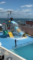 En vandpark med flere vandrutsjebaner og vandattraktioner, en swimmingpool og havudsigt.