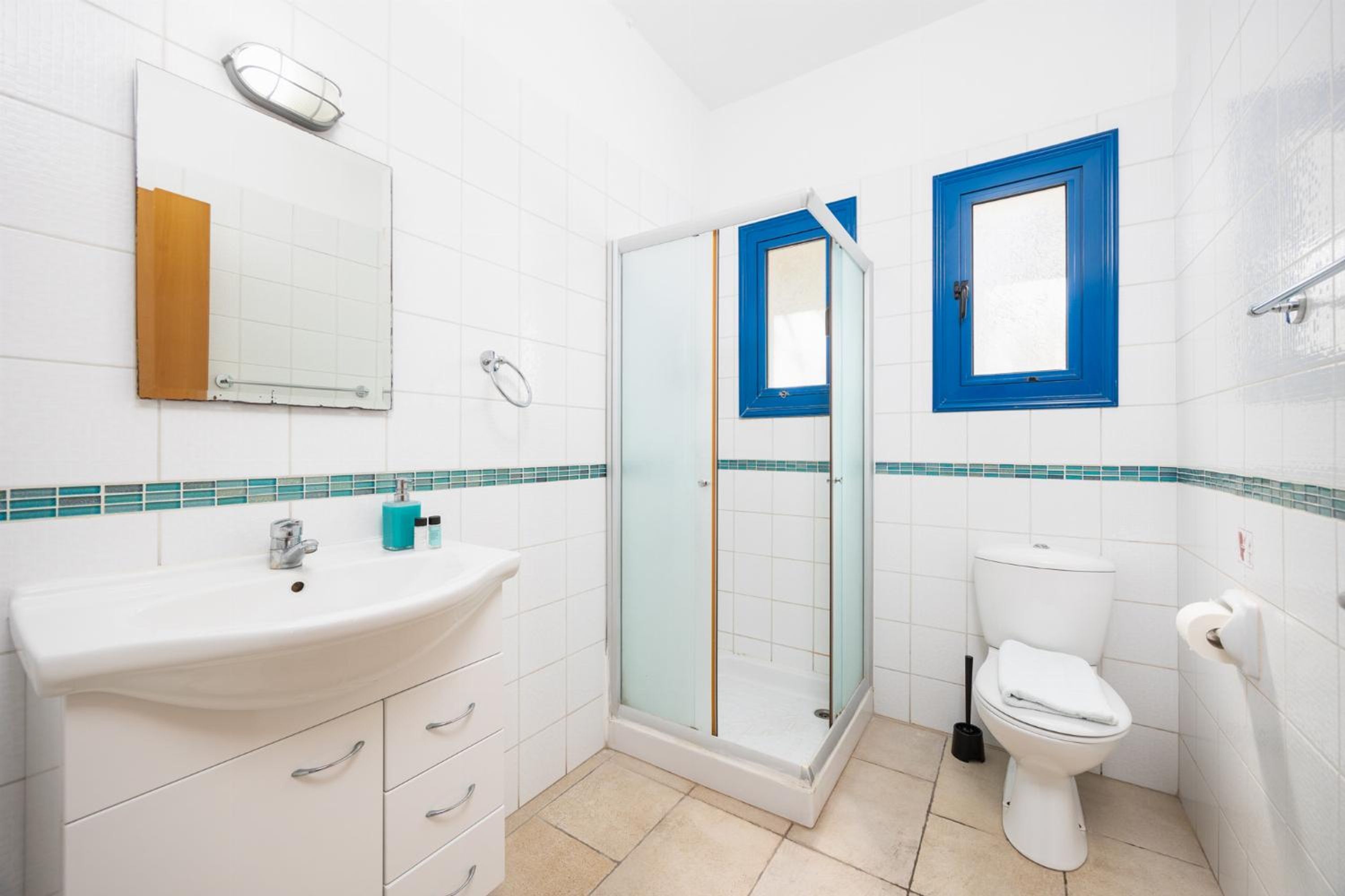 A bathroom with a white sink, a glass shower enclosure, and a toilet.