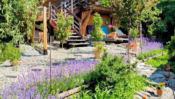 Een houten chalet met een schuin dak en een trap naar een terras.