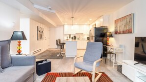 Un appartement moderne comprenant un salon, une cuisine et un coin repas.