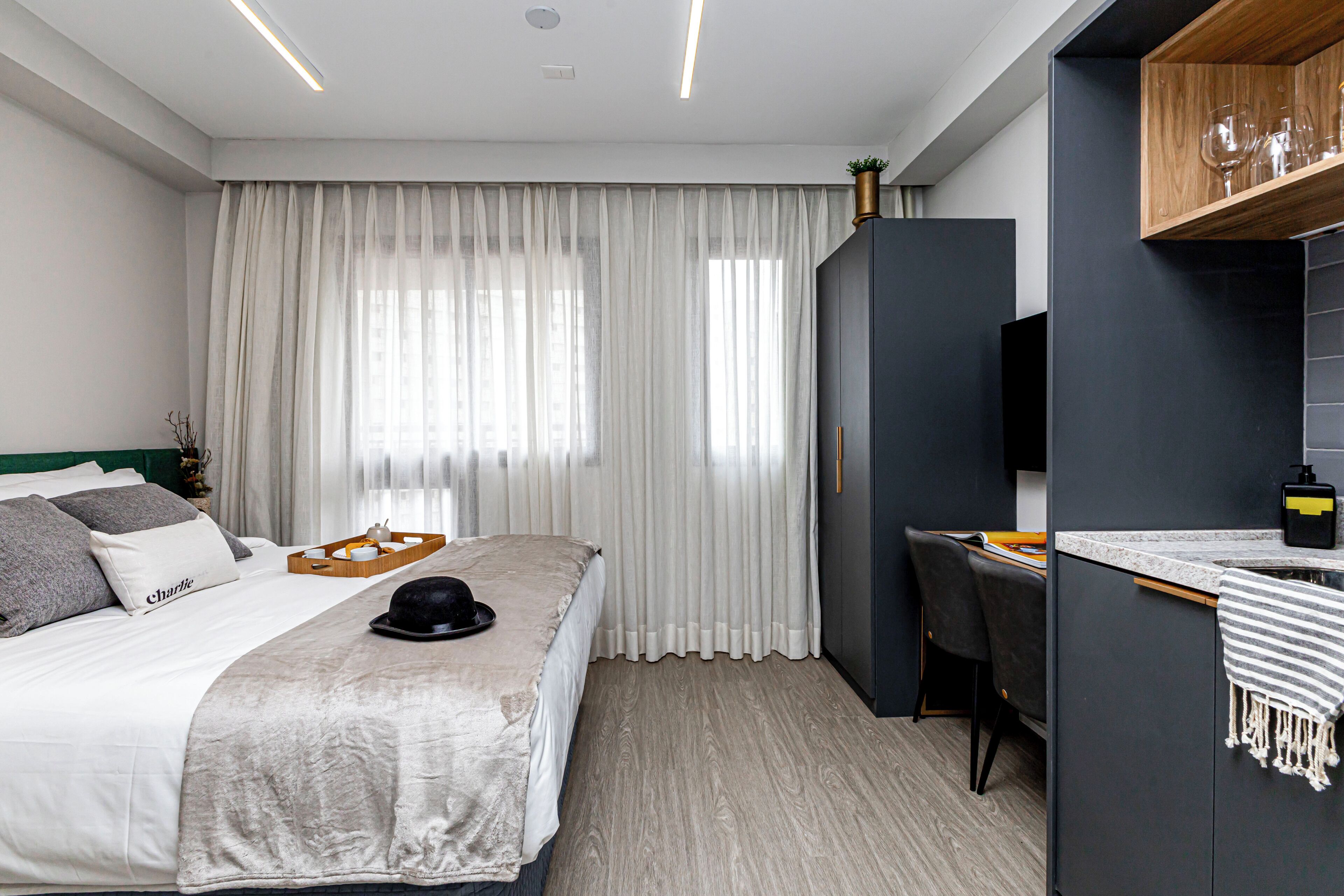 Ein modernes Hotelzimmer mit einem großen Bett, einem Schreibtisch und einem Fernseher.