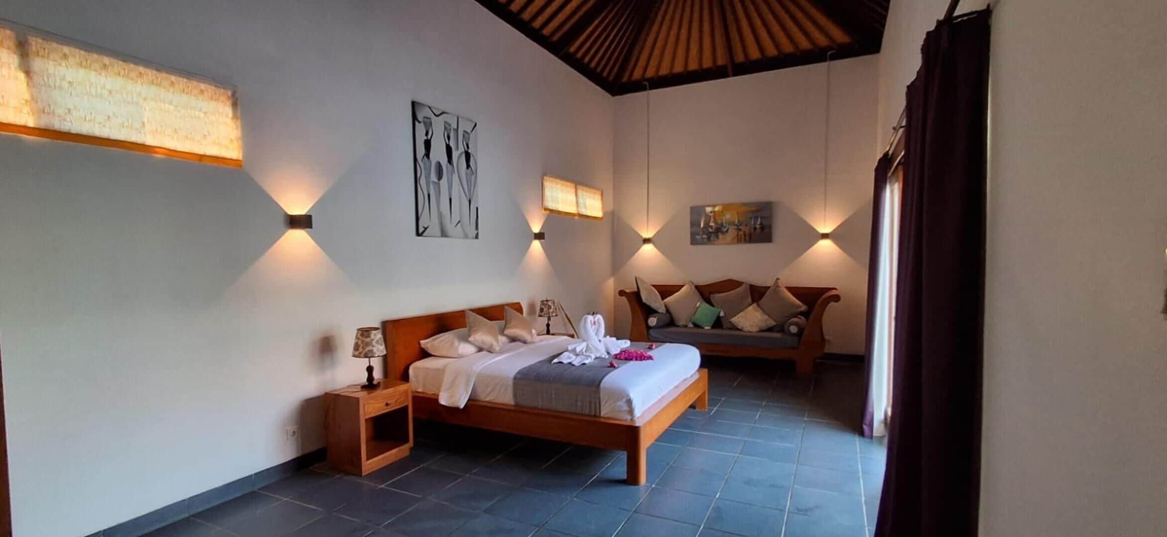Une chambre à coucher avec un lit, une table de chevet et des lampes fixées au mur.