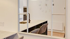 Moderni keittiö, jossa on sisäänrakennettu uuni, pesuallas ja ikkuna.
